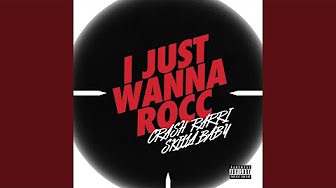 A black and white picture of a round button with the words " i just wanna rocc " written on it.
