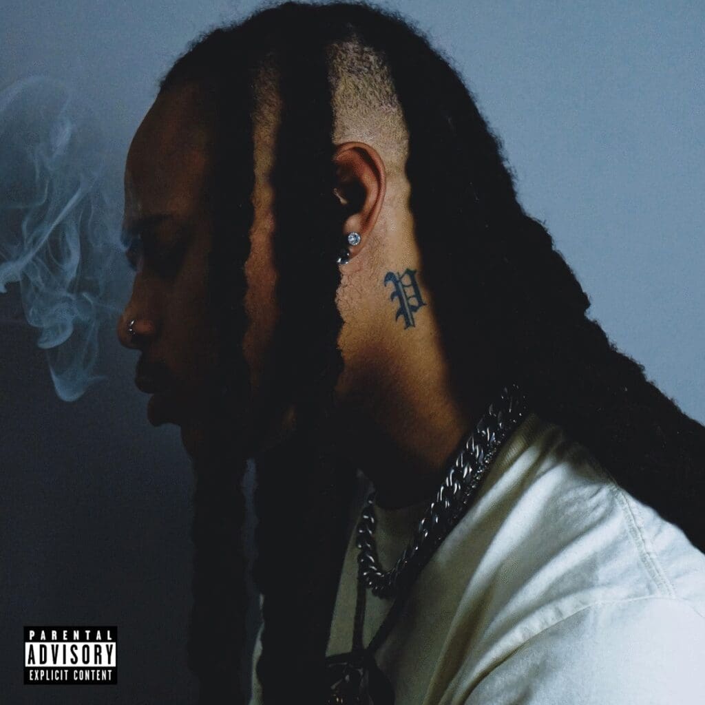 Person with braids and tattoo, side profile.