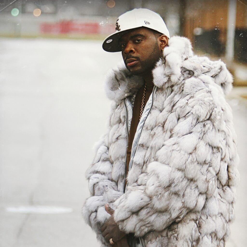 Man in fur coat and white cap.
